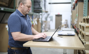 Warehouse manager working on a laptop